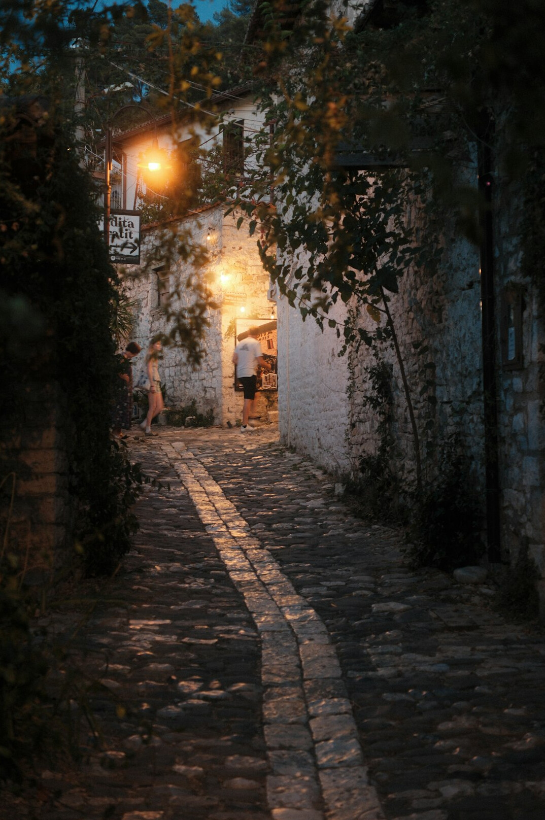Old cobblestone street at dusk with warm lamplight